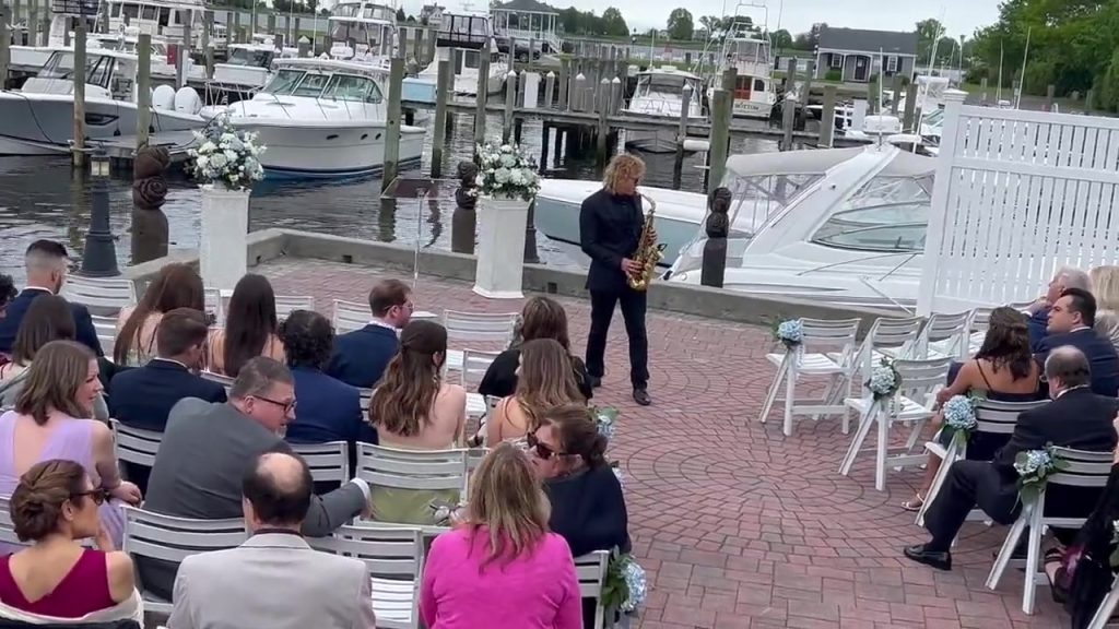 MattyB playing saxophone during a waterfront wedding ceremony in Southwest Florida